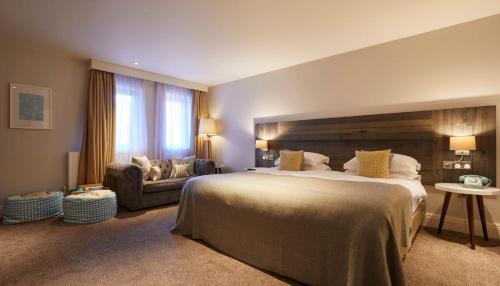 a large bedroom with a large bed and a couch at The Swan, Streatley, Berkshire in Streatley