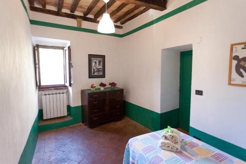 a bedroom with green and white walls and a bed at Foresteria del Teatro Povero in Monticchiello