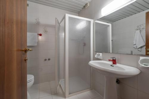uma casa de banho com um lavatório, um chuveiro e um WC. em Hotel Royal em Garda