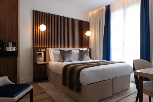 a hotel room with a bed and a window at Lord Byron in Paris