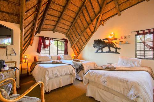 a bedroom with two beds and a tv in a room at All over Africa Guest house in Kempton Park