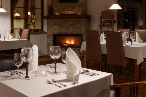 a table in a restaurant with white table cloth and wine glasses at Hotel Singer in Ludvíkov