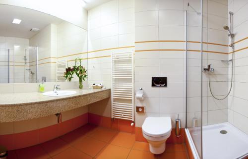 a bathroom with a toilet and a shower and a sink at Hotel Tatra in Bratislava