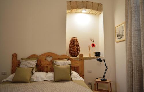 a bedroom with a bed with a wooden headboard at B&B Cose Belle in Capurso