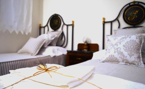 ein Schlafzimmer mit 2 Betten mit weißer Bettwäsche und einer Spinne darauf in der Unterkunft B&B Cose Belle in Capurso