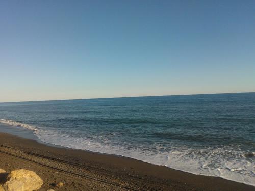 uma vista para o oceano a partir de uma praia arenosa em Camping Valle Niza Playa em Benajarafe