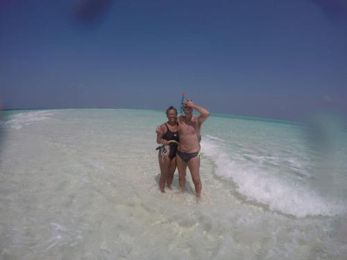 two people standing in the water on the beach at Malas Island View in Fulidhoo