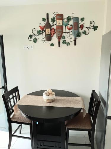 a black table with chairs and wine glasses on a wall at Apartment with pool in Mindelo in Mindelo
