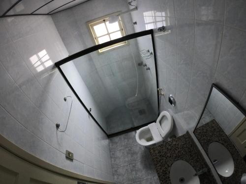 a bathroom with a mirror and a toilet and a sink at Pousada Portal do Mar in Cabo Frio