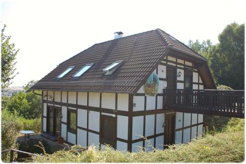 a house with a black and white roof at Apartment Edersee für 4 Personen in Frankenau
