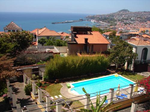 ein Haus mit Swimmingpool und Blick auf das Meer in der Unterkunft Purple Studio in Funchal