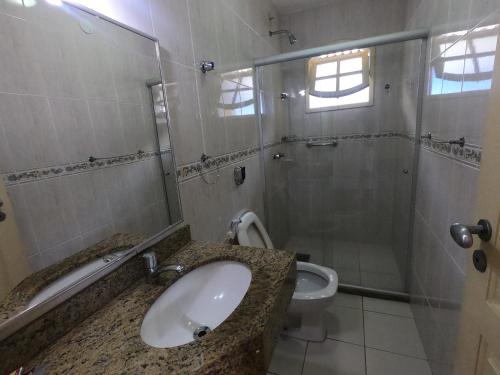 a bathroom with a sink and a shower at Pousada Portal do Mar in Cabo Frio