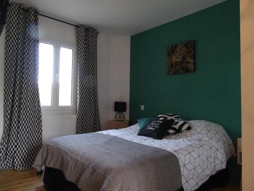a bedroom with a bed and a green wall at Casa Juno in Duvy