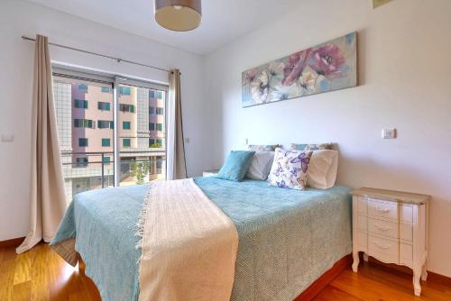 Blue Sky Apartment with pool by HR MADEIRA tesisinde bir odada yatak veya yataklar