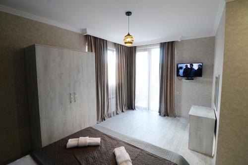 a bedroom with a bed and a tv on the wall at Friendship House in Tbilisi City