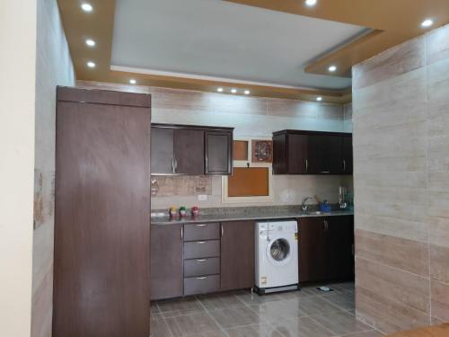 a kitchen with a washing machine and a washer at Ramco For Furnished Apartments And Accommodation Compound Leila in Cairo