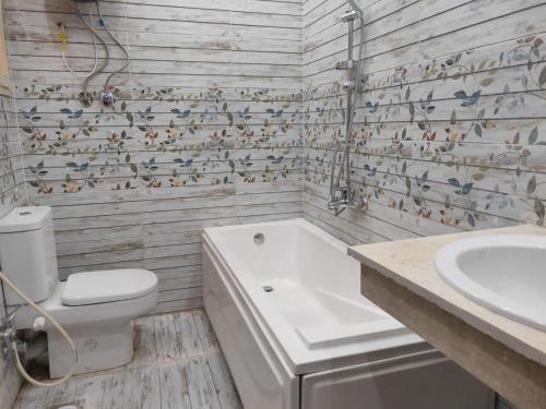 a bathroom with a tub and a toilet and a sink at Ramco For Furnished Apartments And Accommodation Compound Leila in Cairo