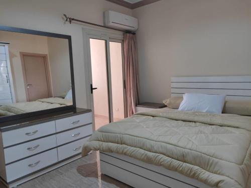 a bedroom with a bed with a mirror and a dresser at Ramco For Furnished Apartments And Accommodation Compound Leila in Cairo