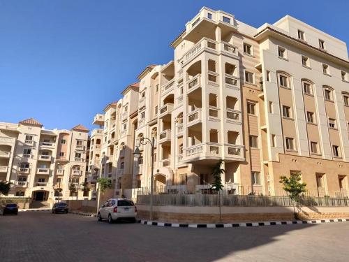 a large building with a car parked in front of it at Ramco For Furnished Apartments And Accommodation Compound Leila in Cairo