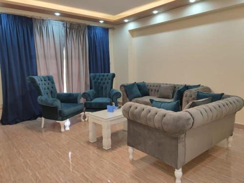 a waiting room with a couch and chairs and a screen at Ramco For Furnished Apartments And Accommodation Compound Leila in Cairo