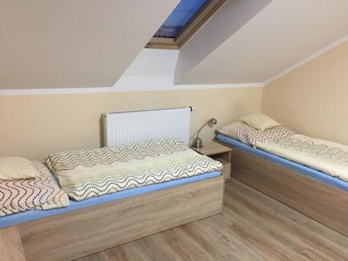 two beds in a room with wooden floors at Pod Kotwicą in Nowa Sól