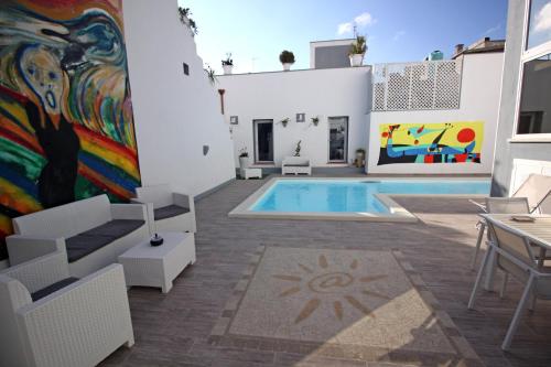 ein Haus mit einem Pool und einem Gemälde an der Wand in der Unterkunft Salentuosi - Salento Mille e una Notte in Racale