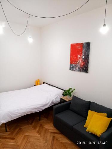 a bedroom with a bed and a couch and a painting at Gogol 14 Апартаменти в історичному центрі міста in Uzhhorod