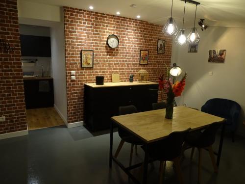 a kitchen with a table and a brick wall at Casa Juno in Duvy