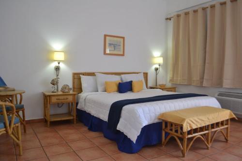 1 dormitorio con 1 cama grande con almohadas azules y amarillas en Parador Boquemar, en Boquerón