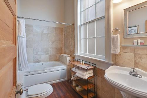 a bathroom with a tub and a sink and a toilet at Elysian Fields Inn in New Orleans
