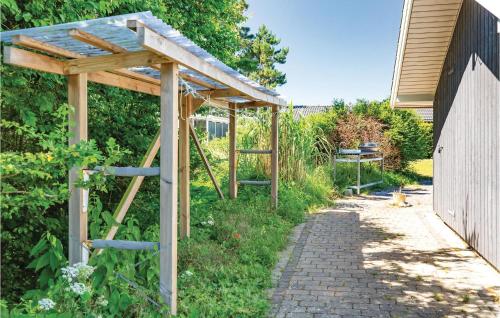 a wooden pergola in a garden next to a building at Amazing Home In Slagelse With Kitchen in Slagelse
