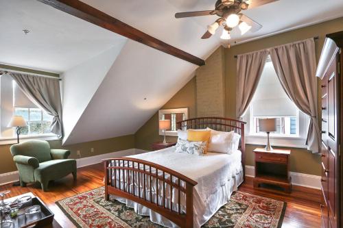 a bedroom with a bed and a chair and windows at Elysian Fields Inn in New Orleans