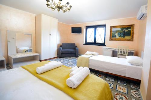 une chambre d'hôtel avec deux lits et une chaise dans l'établissement Domus Ansantica, à Villamaina