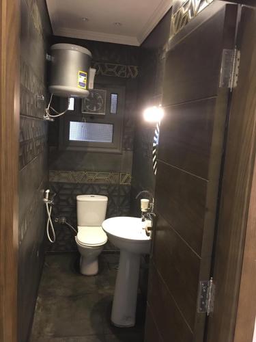 a small bathroom with a toilet and a sink at Ramco For Furnished Apartments And Accommodation Compound Leila in Cairo