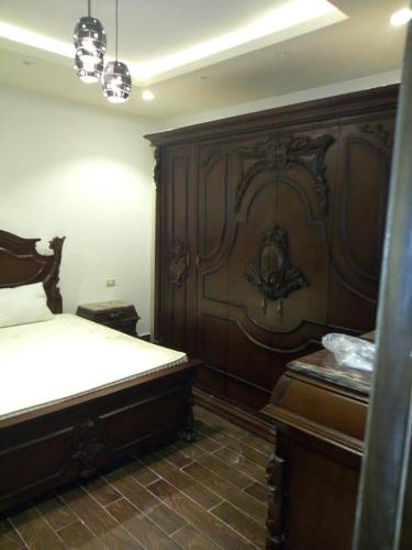a bedroom with a bed and a wooden wall at Ramco For Furnished Apartments And Accommodation Compound Leila in Cairo