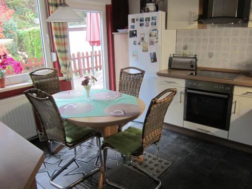 eine Küche mit einem Tisch mit Stühlen und einem Kühlschrank in der Unterkunft Dani´s Feriendomizil in Wieda