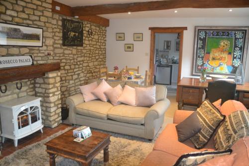 a living room with a couch and a fireplace at Church Cottage Barn in Longborough