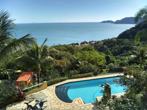 a swimming pool with a view of the ocean at Vila Lia in São Sebastião