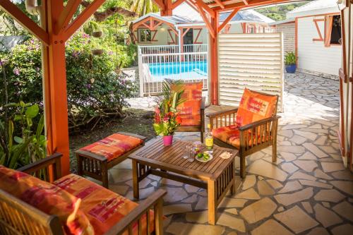 a patio with a table and chairs and a pool at Les jardins de Pointe Noire in Pointe-Noire