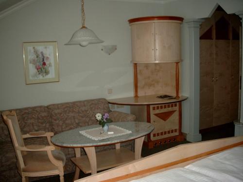 a living room with a table and a couch at Das-Schmidt Privathotel in Mörbisch am See