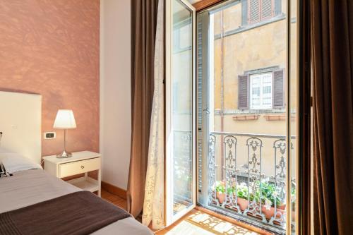 um quarto com uma cama e uma grande janela em Urbana Apartment Colosseum em Roma