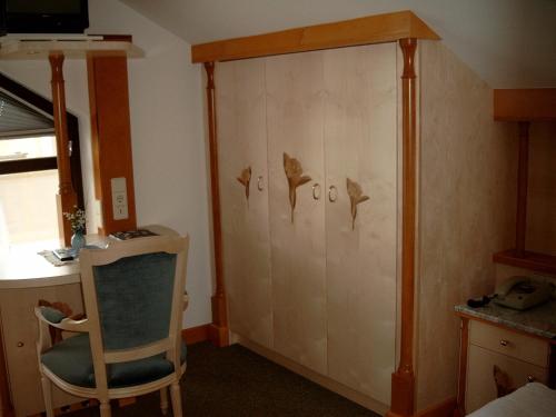 a room with a chair and a wall with birds on it at Das-Schmidt Privathotel in Mörbisch am See