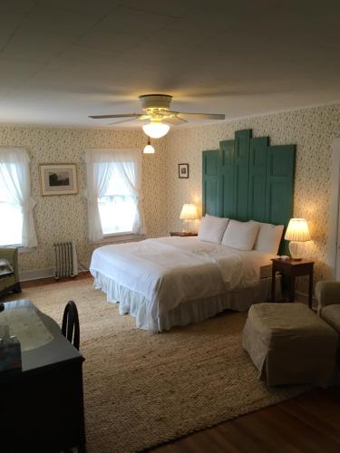 a bedroom with a large bed with a green headboard at House on Chase Creek in Shelter Island Heights