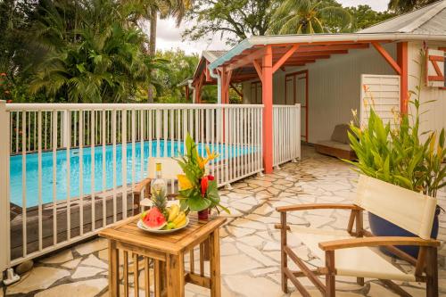 a table with a bowl of fruit next to a pool at Les jardins de Pointe Noire in Pointe-Noire