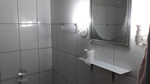 a bathroom with a shower with a mirror and a sink at Edifício Belio in Cascavel