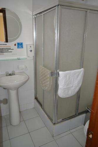 a bathroom with a shower with a toilet and a sink at Hotel Casa Kolping Quito in Quito