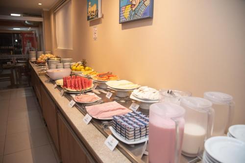 a buffet line with many plates of food and drinks at Getúllio Hotel in Cuiabá