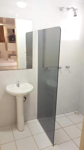 a bathroom with a shower and a sink at L'acqua Motel Express in Ponta Grossa