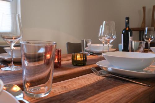 a wooden table with glasses and a plate and a bowl at Feriendomizil "Alte Post" II in Pronsfeld