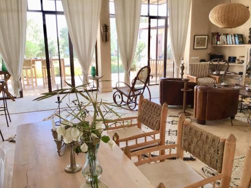 a living room with a table and chairs at Dar Alya Essaouira Maison et table d'hôtes in Ghazoua